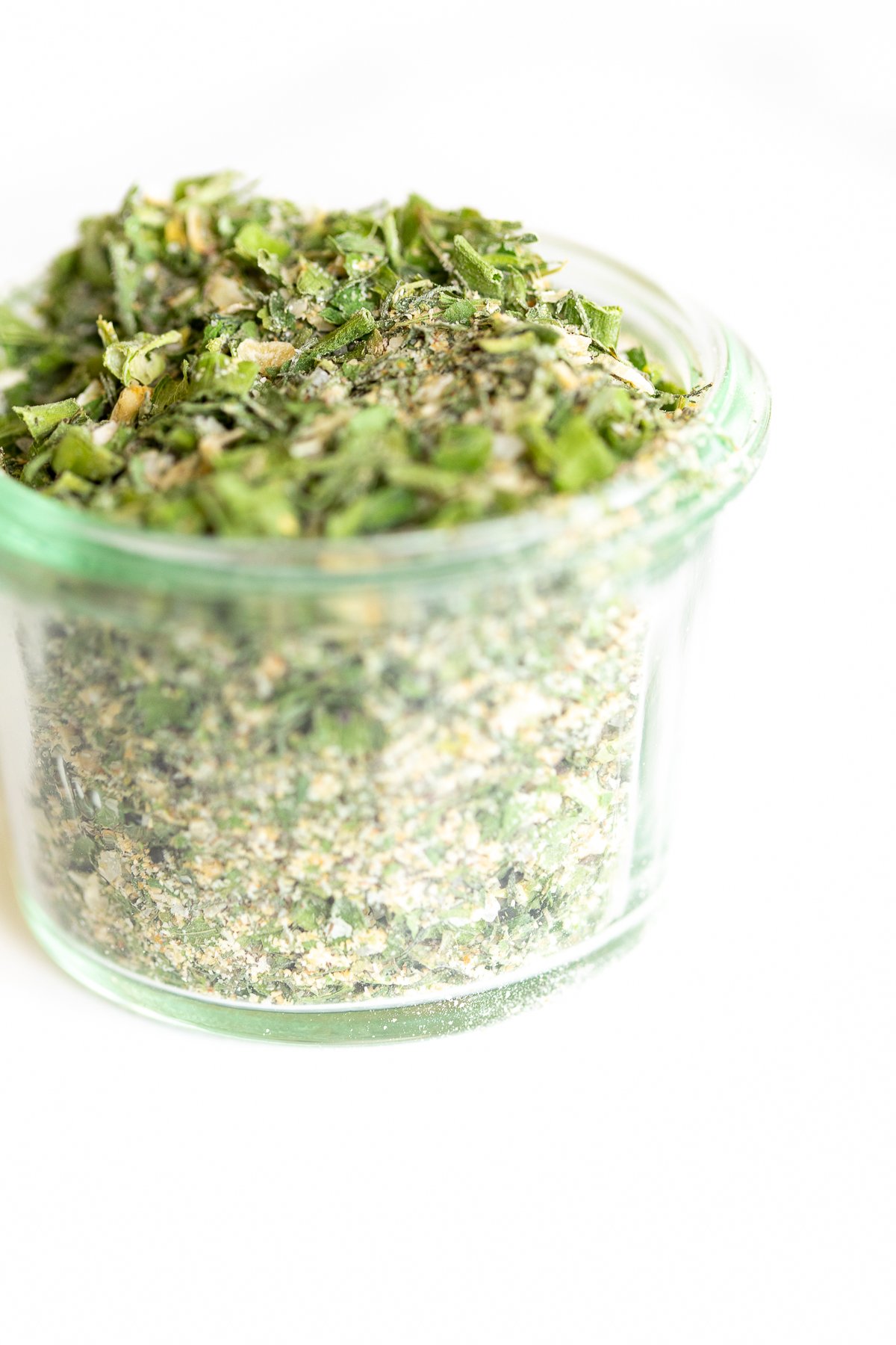 Glass jar of homemade ranch seasoning on a white countertop.