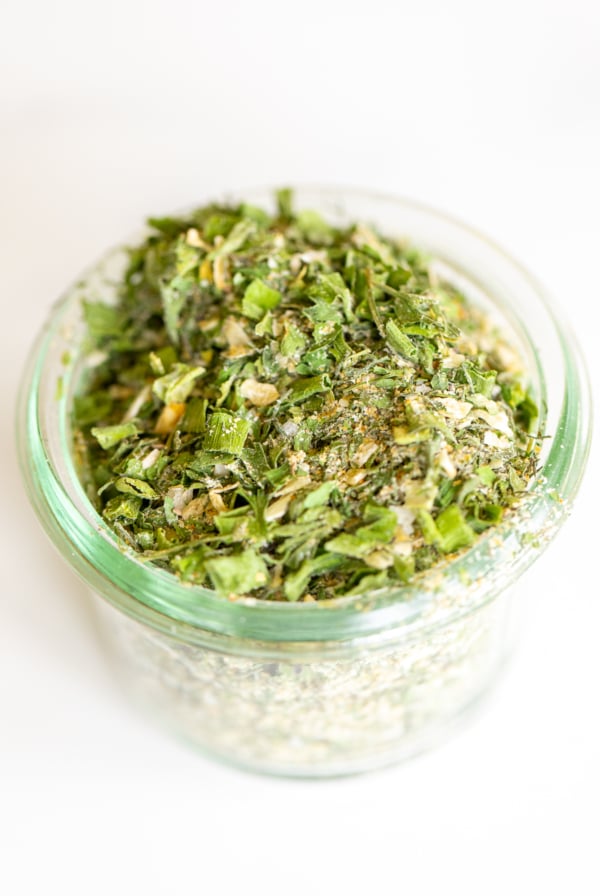 Glass jar of homemade ranch seasoning on a white countertop.