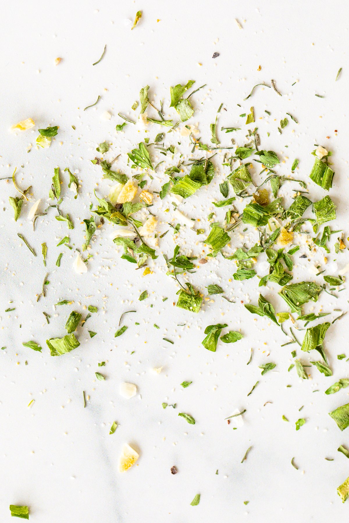 Homemade ranch seasoning sprinkled across a white marble countertop.