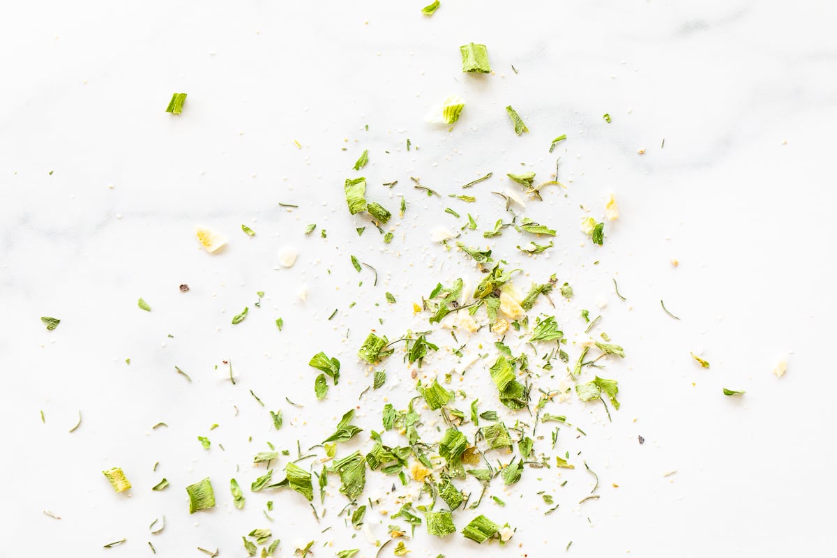 Homemade ranch seasoning sprinkled across a white marble countertop.