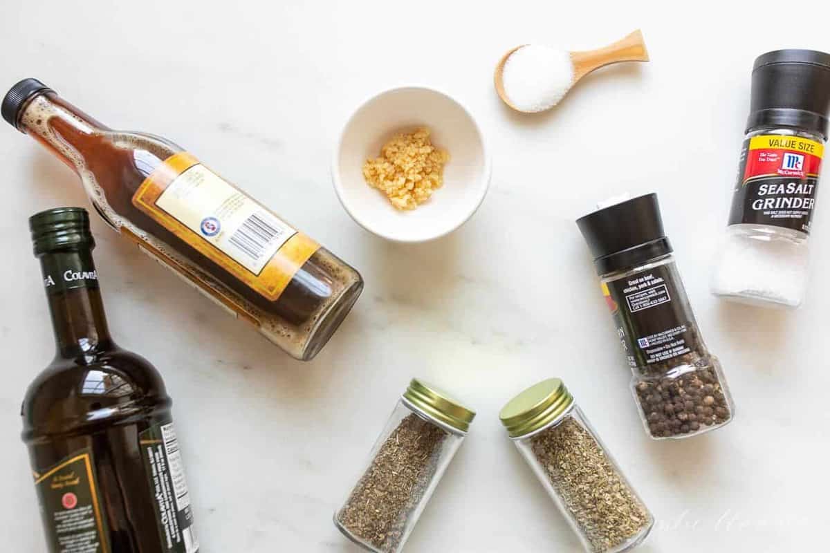 A marble surface filled with herbs and seasonings to make a homemade Italian dressing.