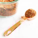A jar of best steak seasoning with a spoon next to it.