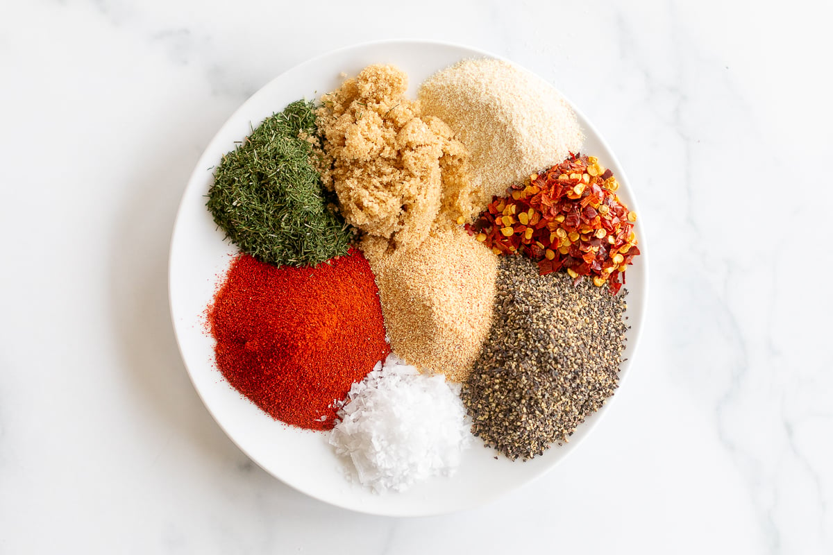 Spices and Steak Seasoning on a white plate.