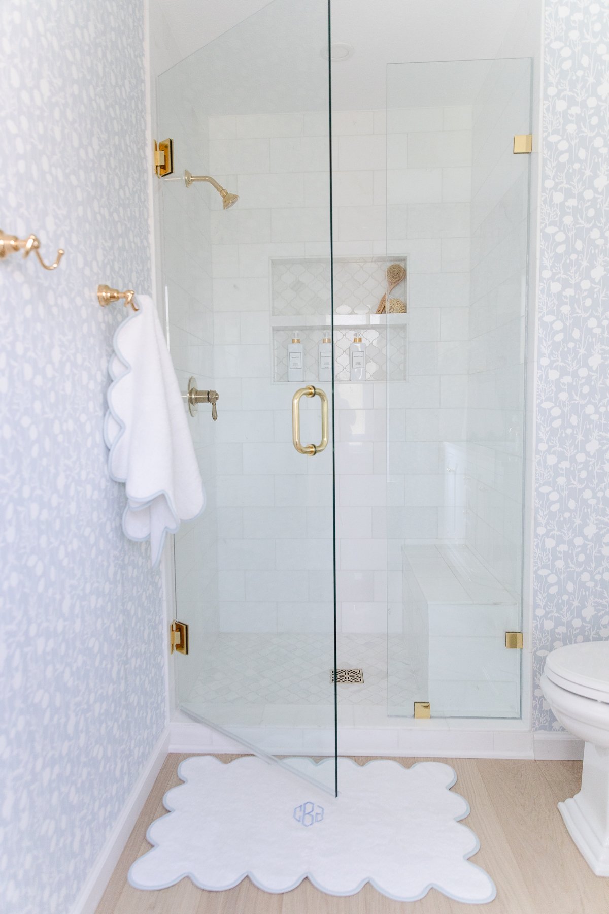 A white tiled shower with a glass door