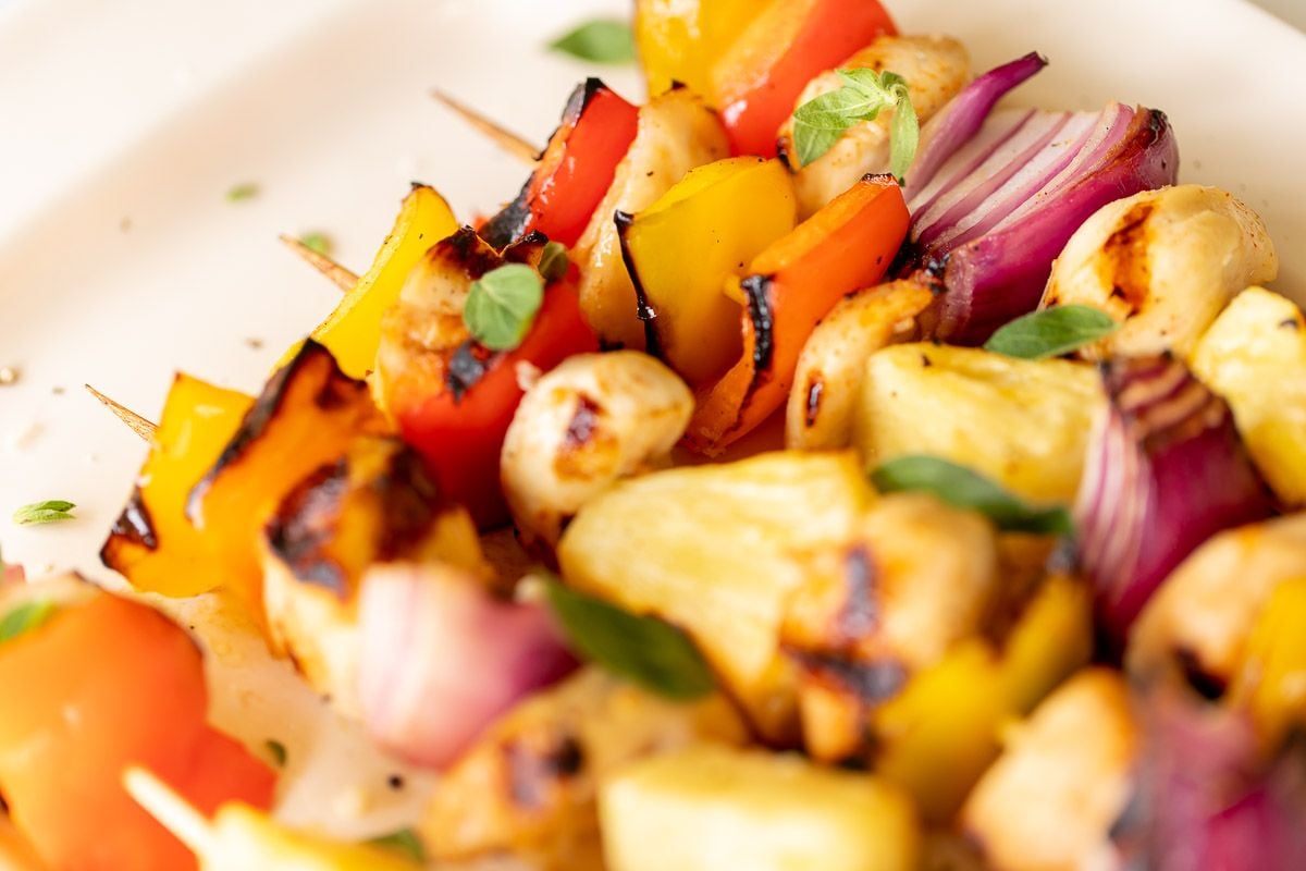 chicken kabobs on a white platter