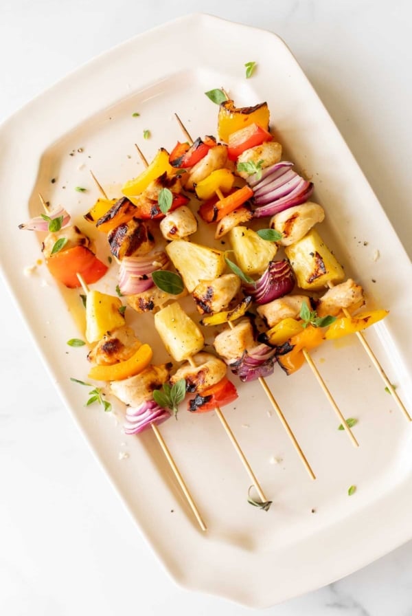 chicken kabobs on a white platter