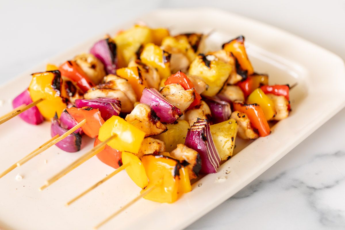 grilled chicken kabobs on a white platter