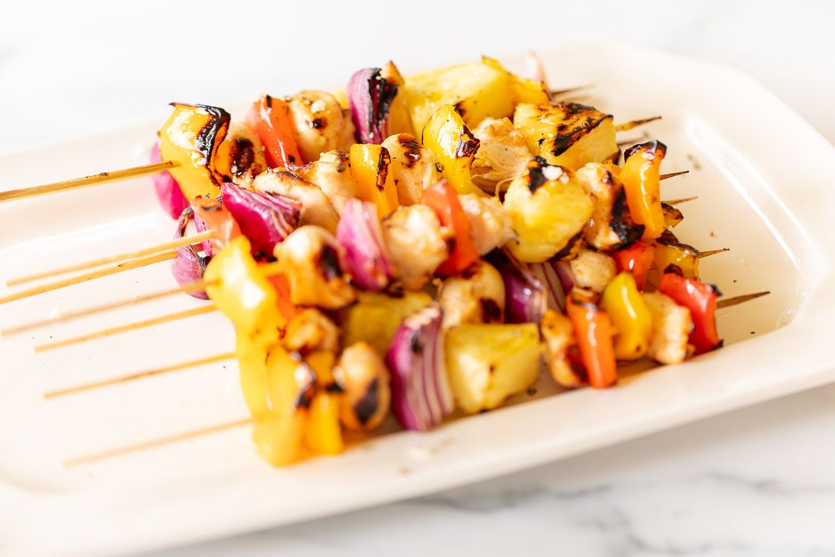 grilled chicken kabobs on a white platter
