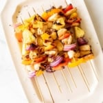 grilled chicken kabobs on a white platter