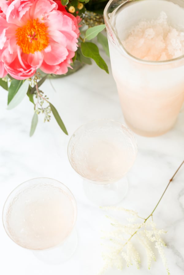 A pitcher of pink sangria-turned-frosé on a marble table.