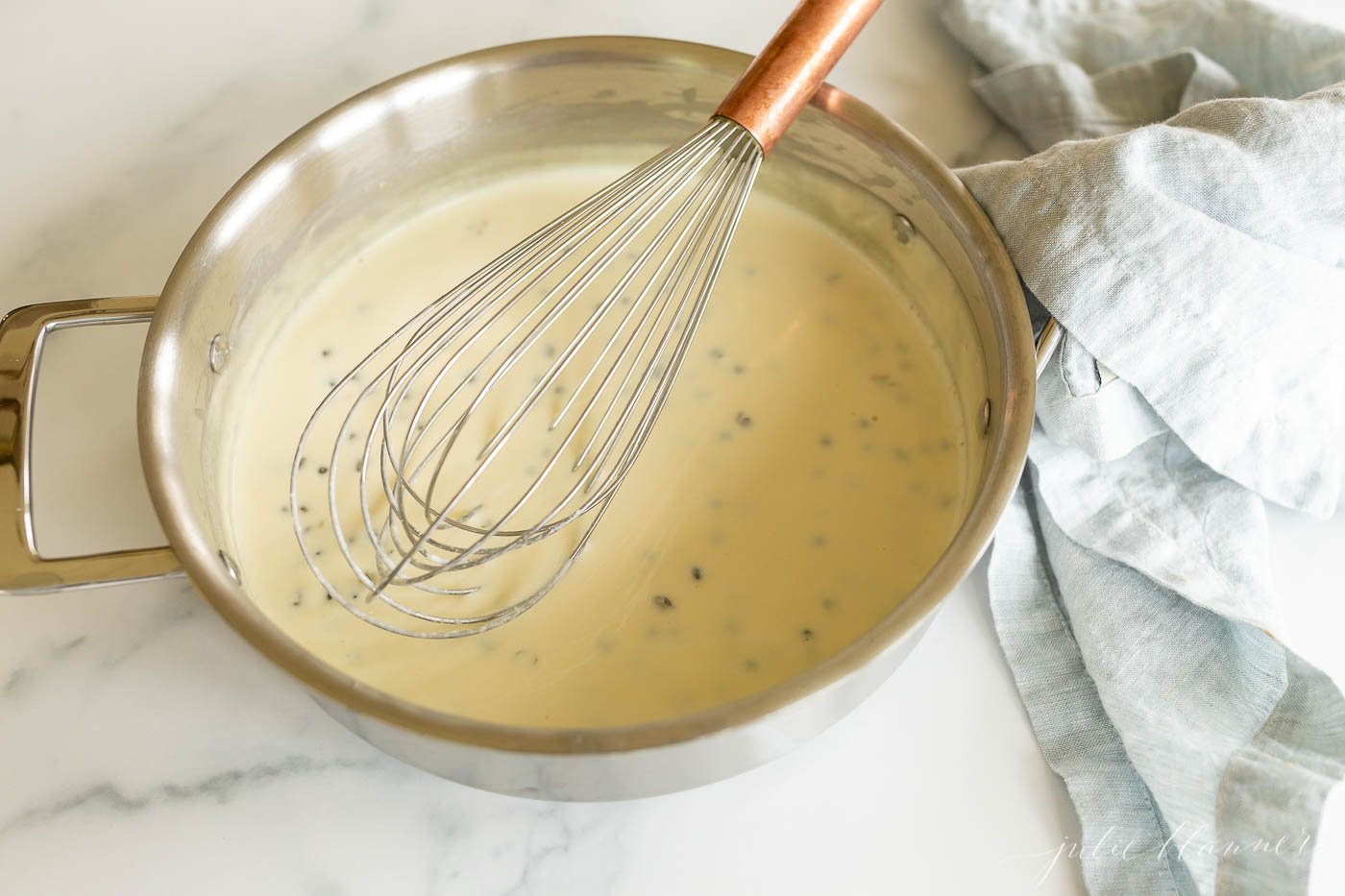 A stainless steel pan filled with a white wine lemon caper sauce.