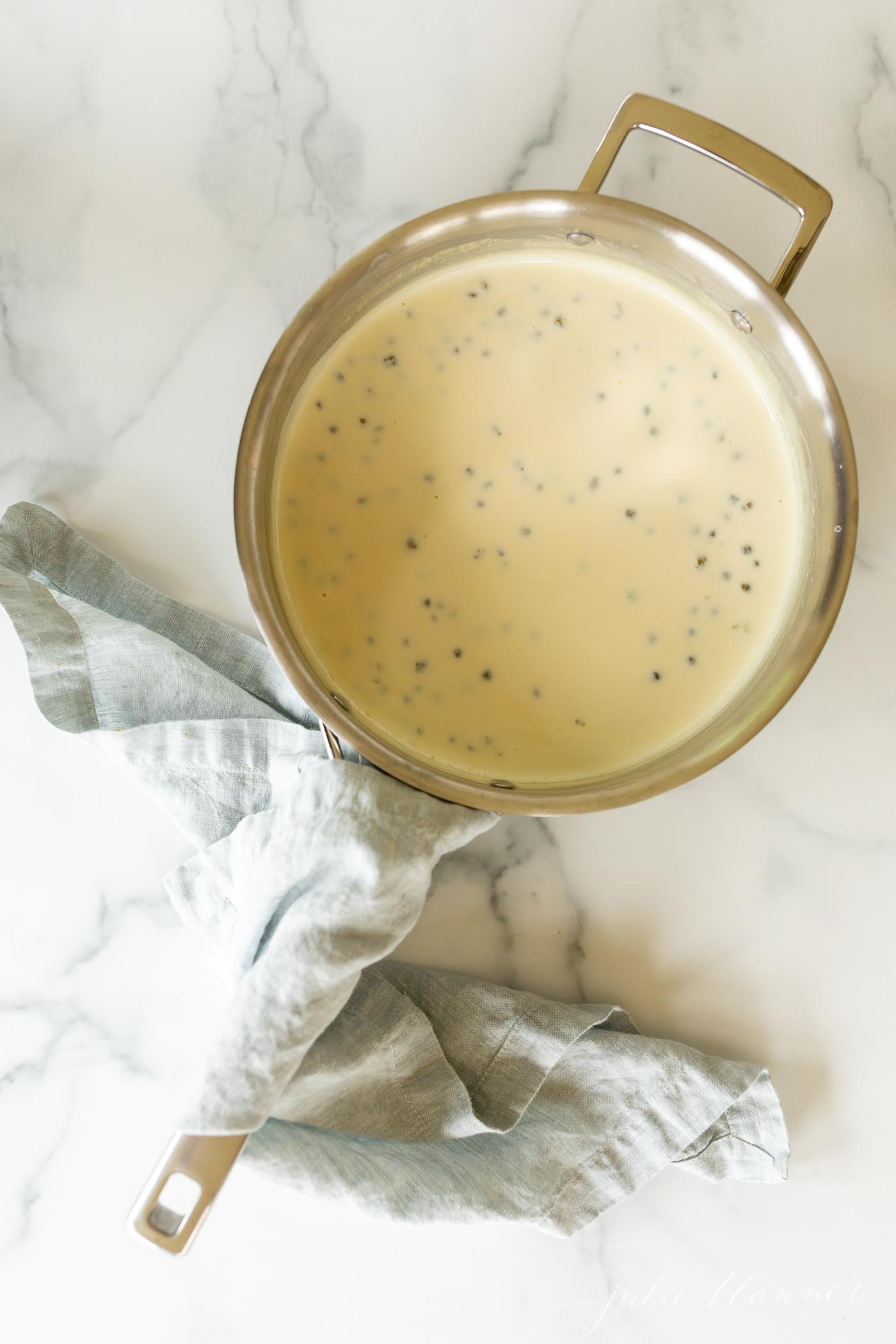 A stainless steel pan filled with a white wine lemon caper sauce.