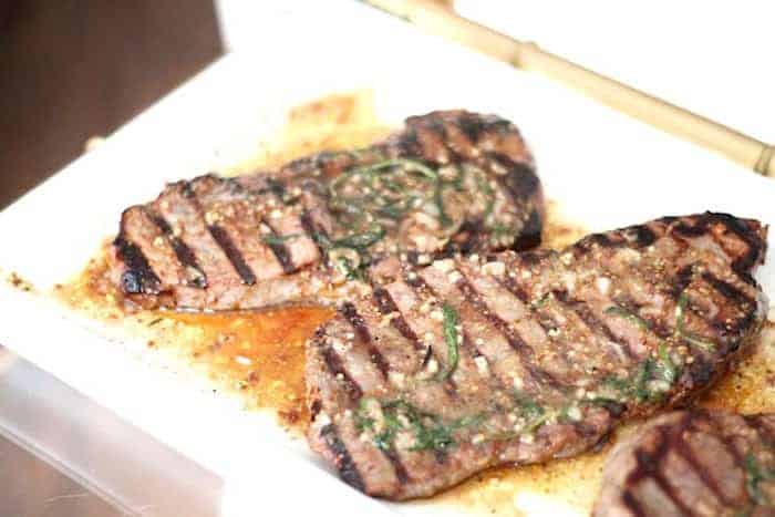 A white tray with grilled marinated steak.