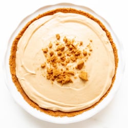 No bake cookie butter cheesecake in a white ceramic pie pan.