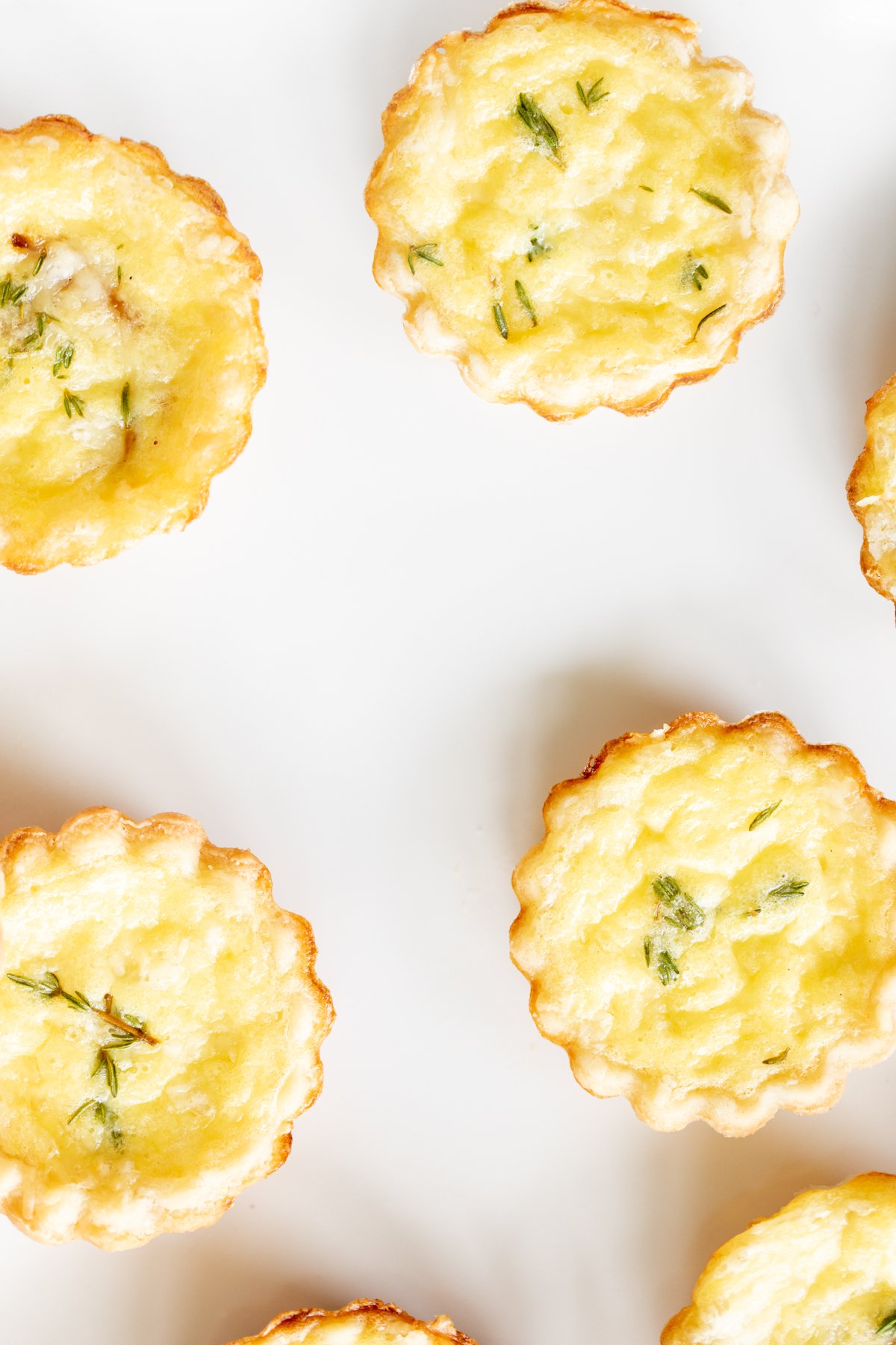 Mini cheese tarts on a white platter.