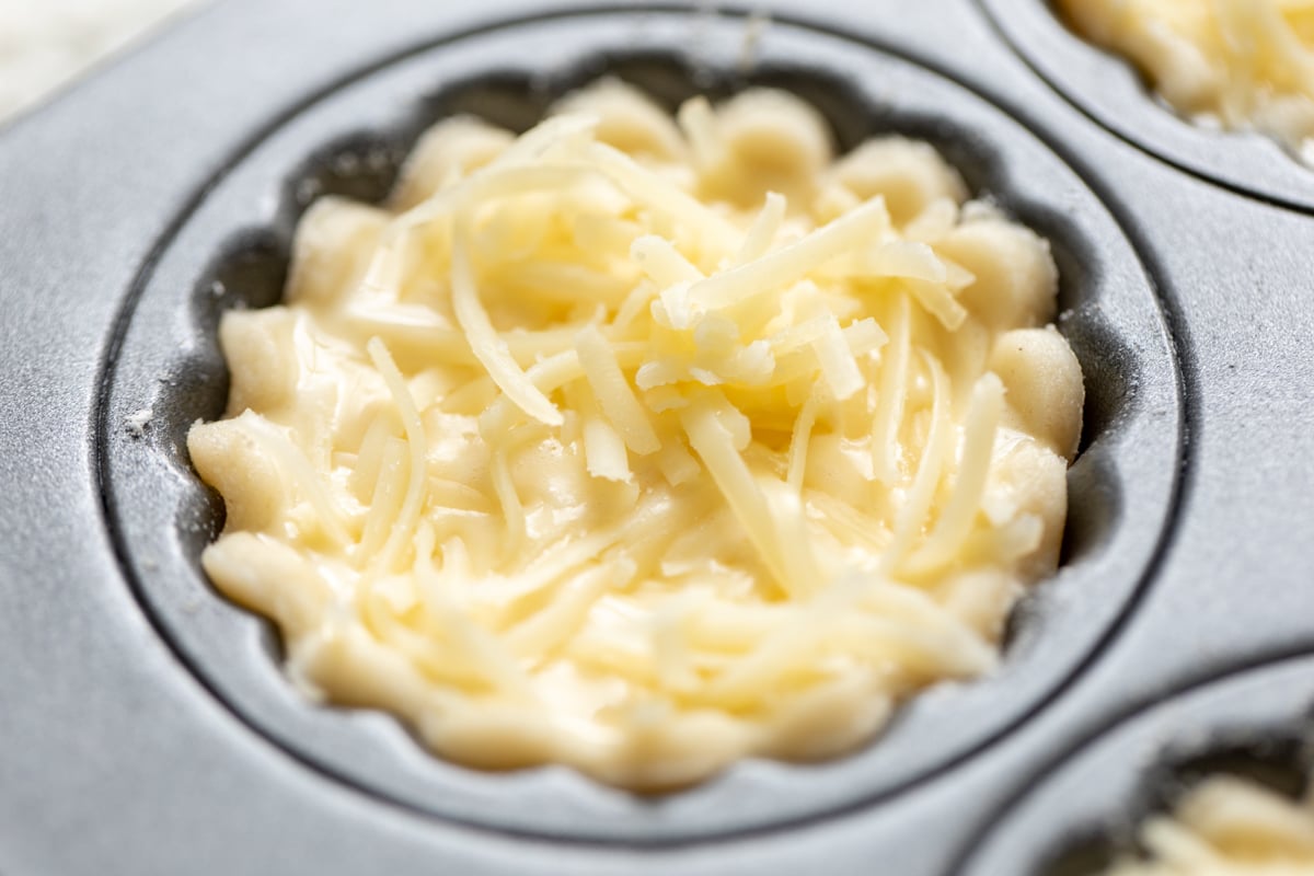 an unbaked cream cheese pie crust cut into a round shape for mini cheese tarts.