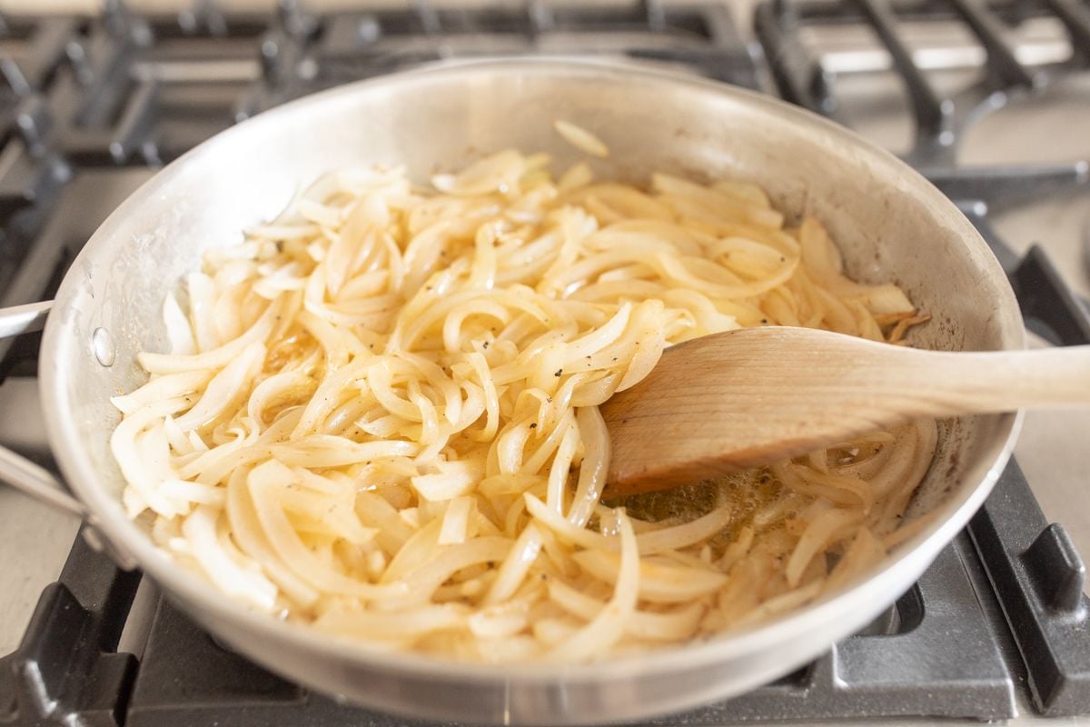 A frying pan with caramelized onions cooking.