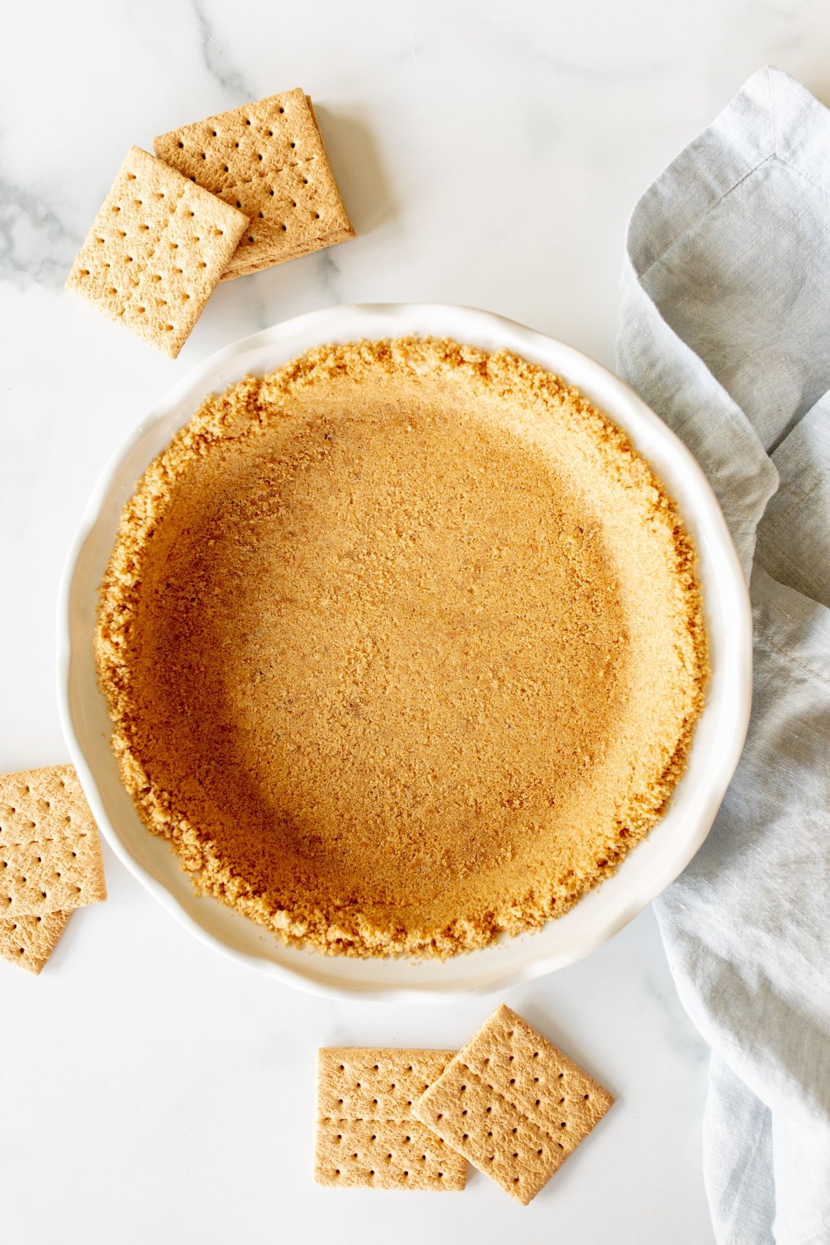 Graham cracker crust in a white pie plate.