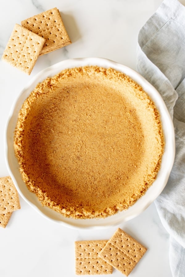 Graham cracker crust in a white pie plate.