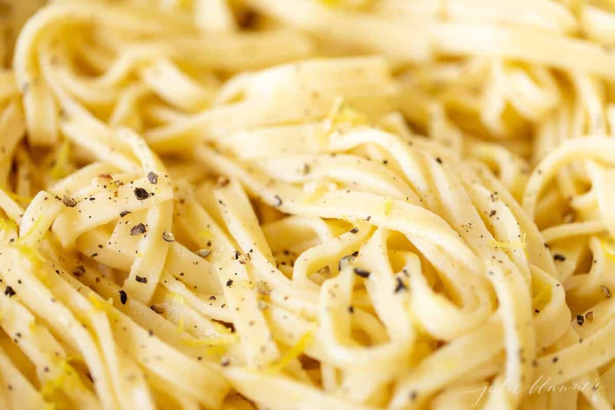 Close up shot of fettuccine noodles covered in a lemon pepper sauce.