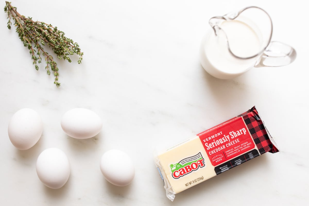 Ingredients for egg and cheese tarts on a marble countertop