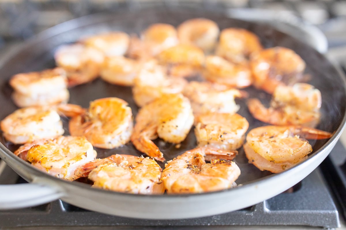 Shrimp cooking in a cast iron skillet.