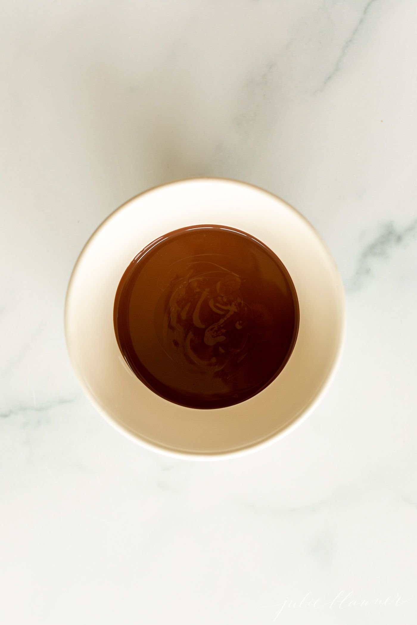 A white bowl of chocolate magic shell.