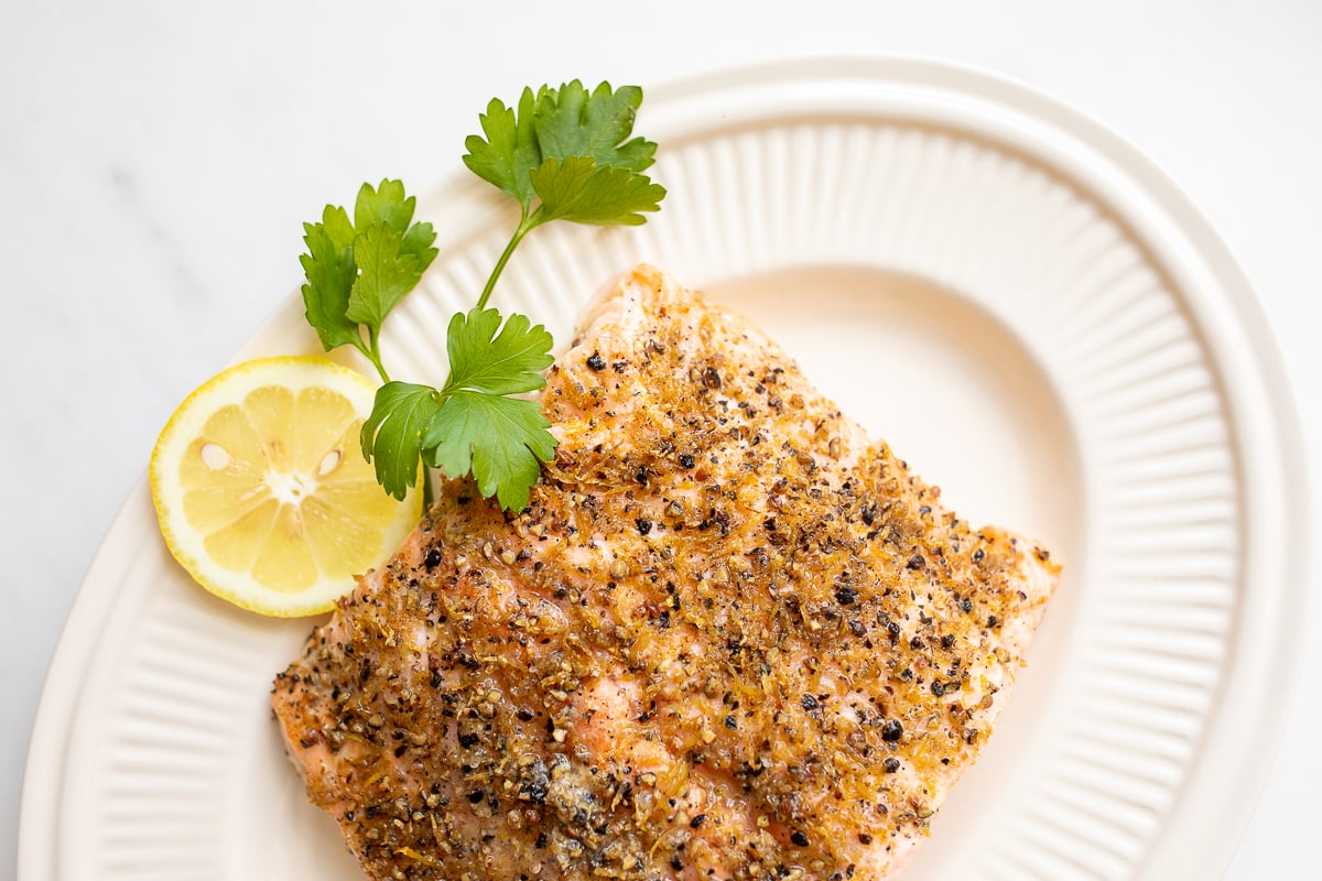 Lemon pepper salmon on a white platter.
