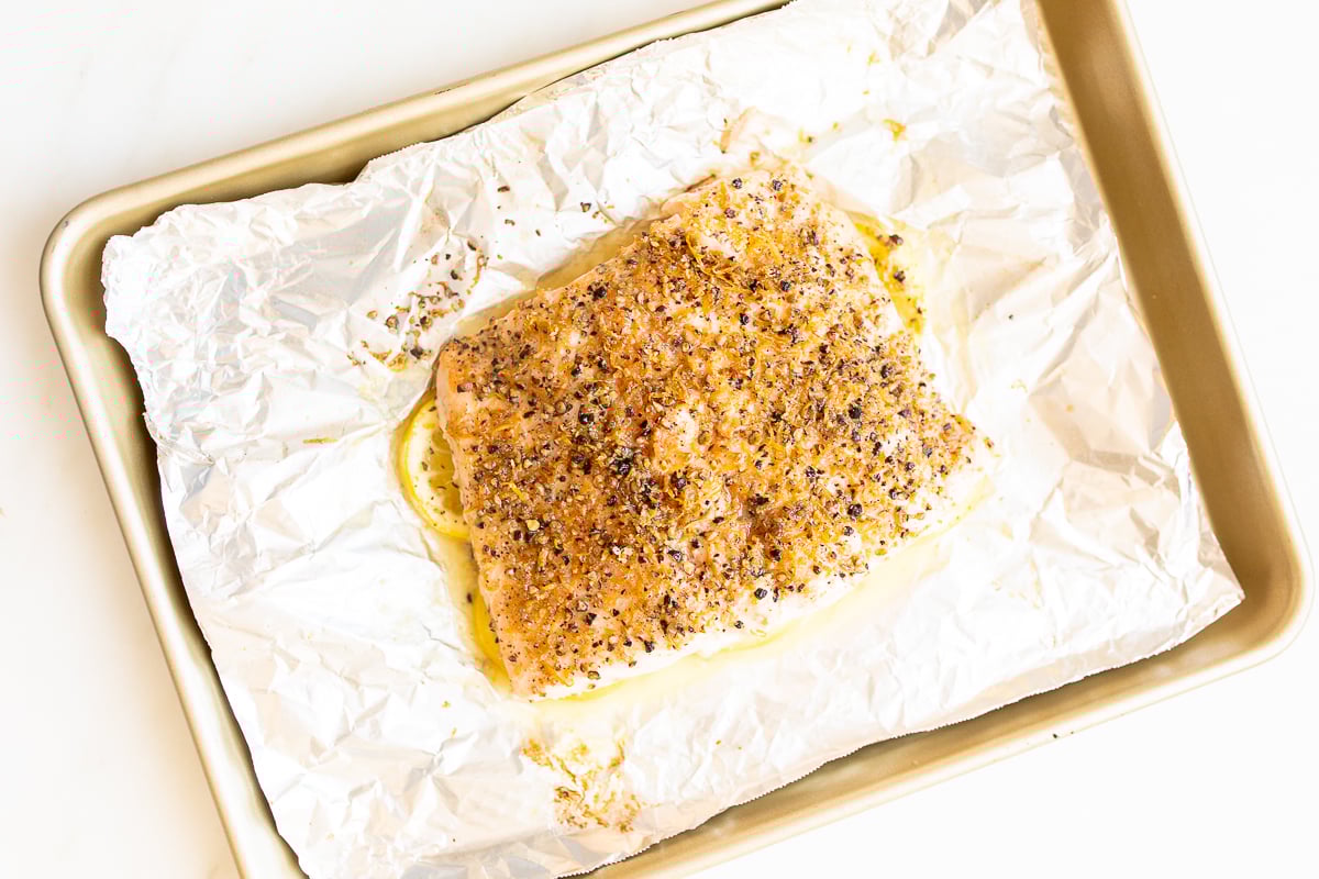 Lemon pepper salmon on a baking sheet.
