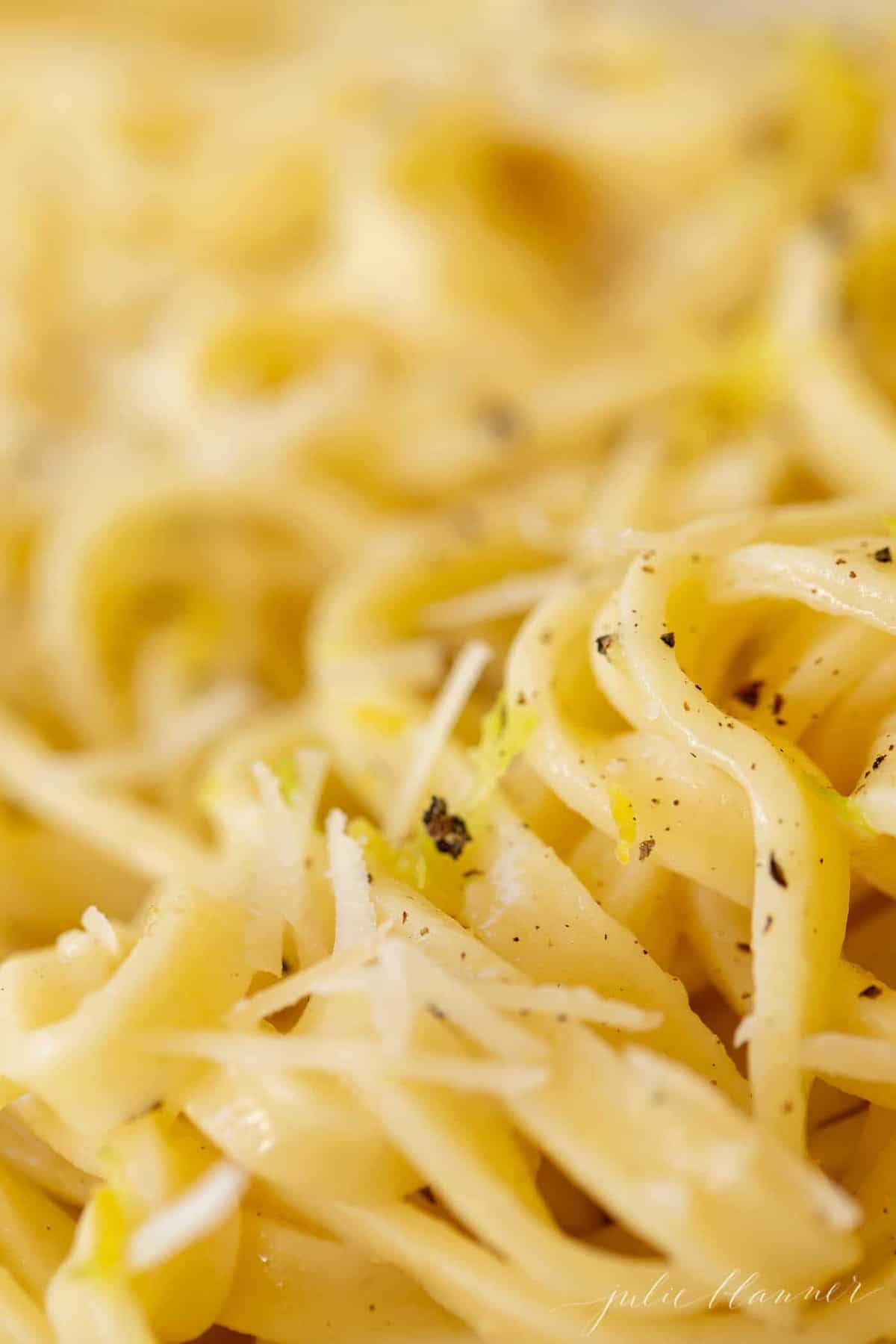 Close up shot of fettuccine noodles covered in a lemon pepper sauce.