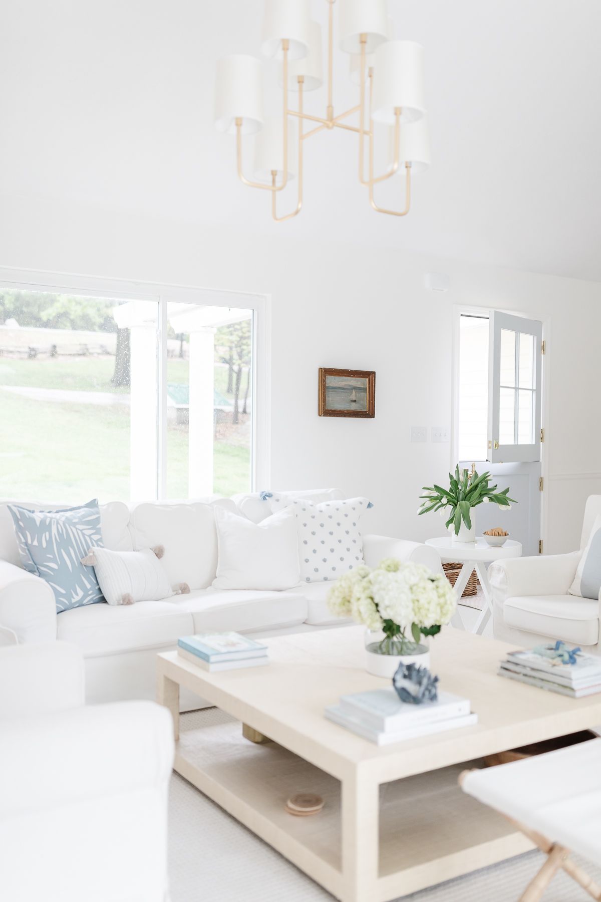 A white living room with white furniture and a raffia coffee table