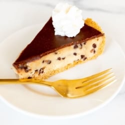 A white plate with a slice of cookie dough pie and a gold fork.