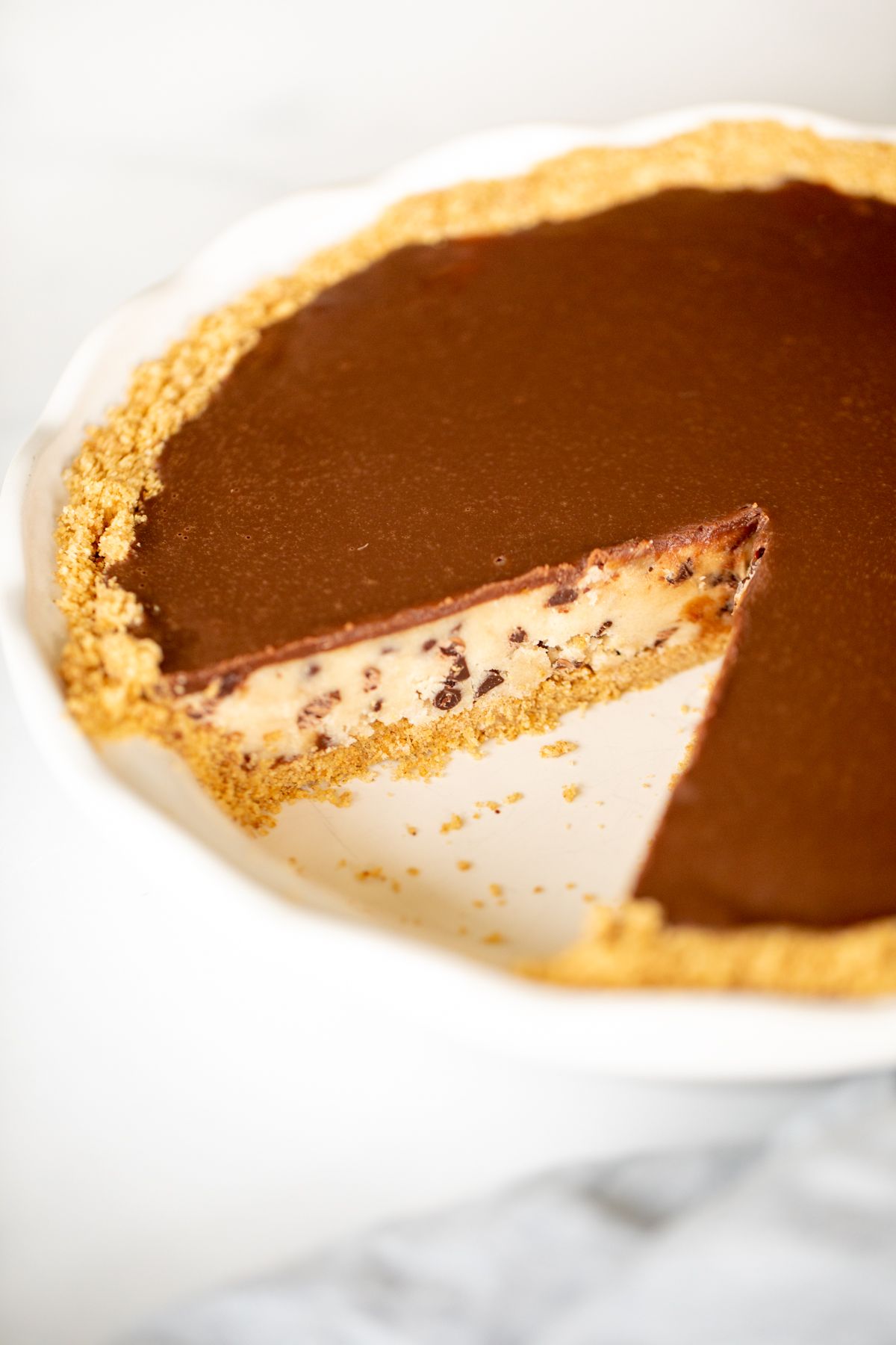 A no bake cookie dough pie with a graham cracker crust, slice removed.