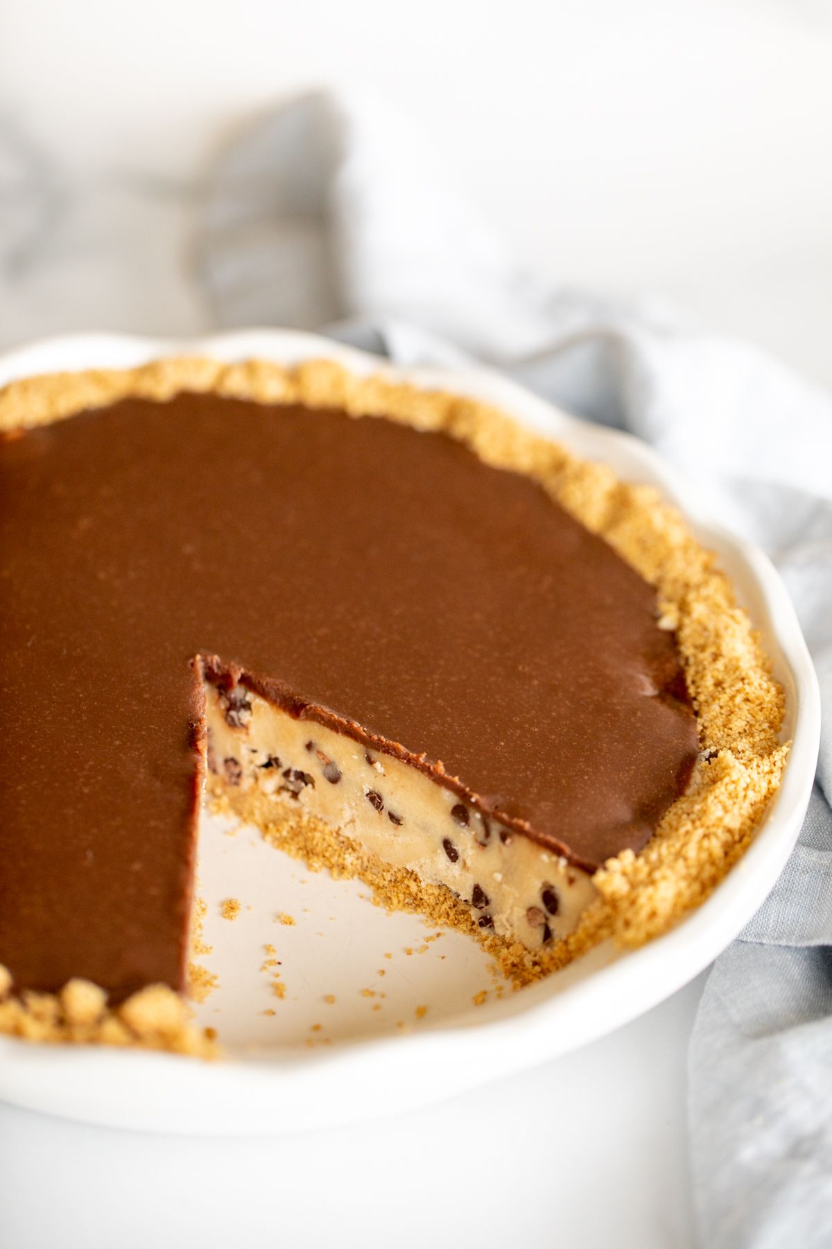 A no bake cookie dough pie with a graham cracker crust, slice removed.