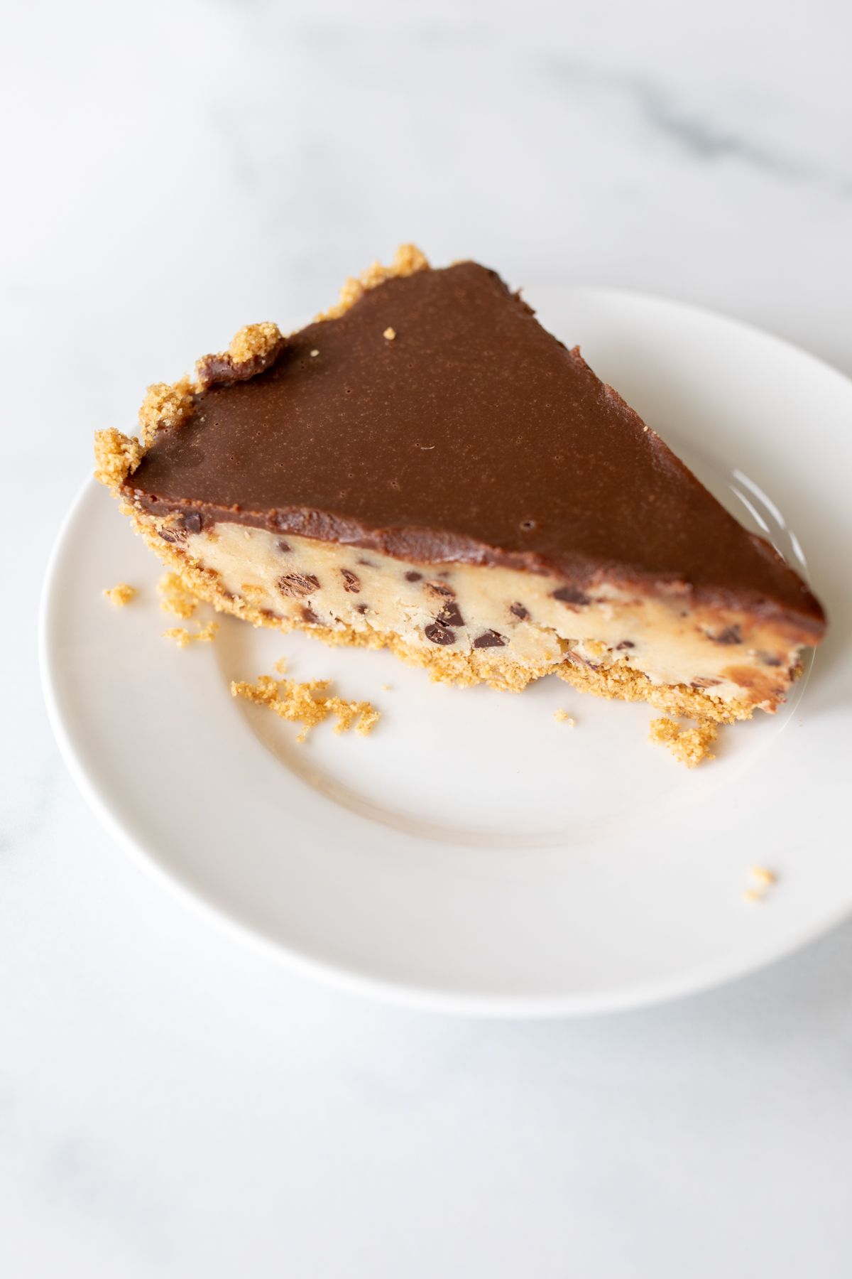 A white plate with a slice of cookie dough pie.