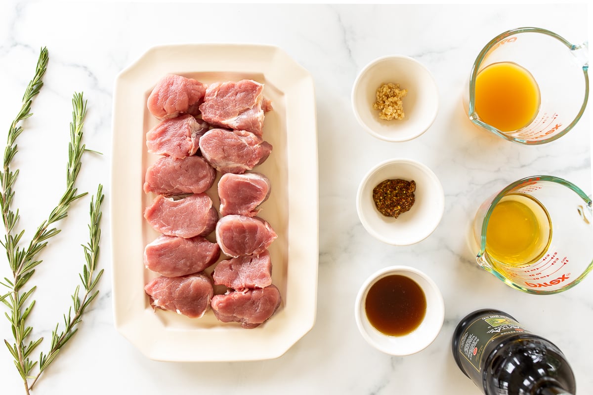 Ingredients for apple cider pork tenderloin medallions on a white countertop.