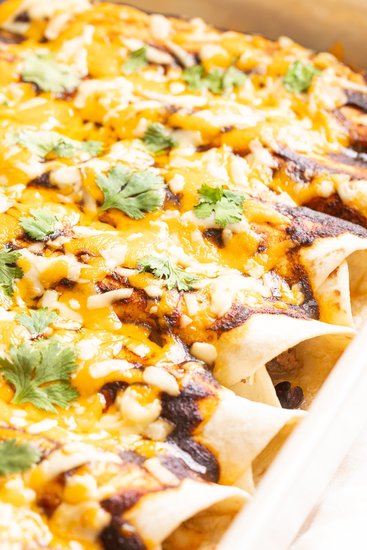 A white pan full of beef enchiladas.