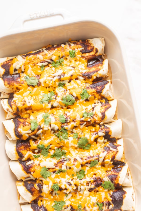 A white pan full of beef enchiladas.