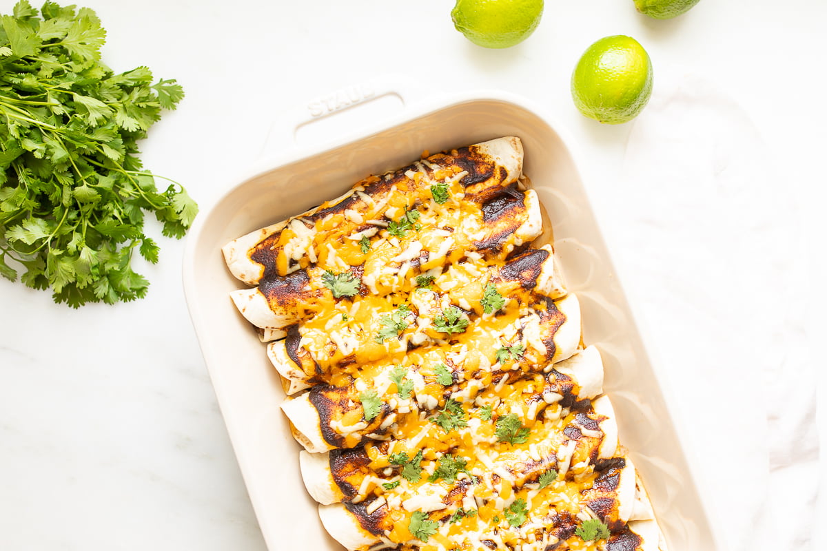A white pan full of beef enchiladas.