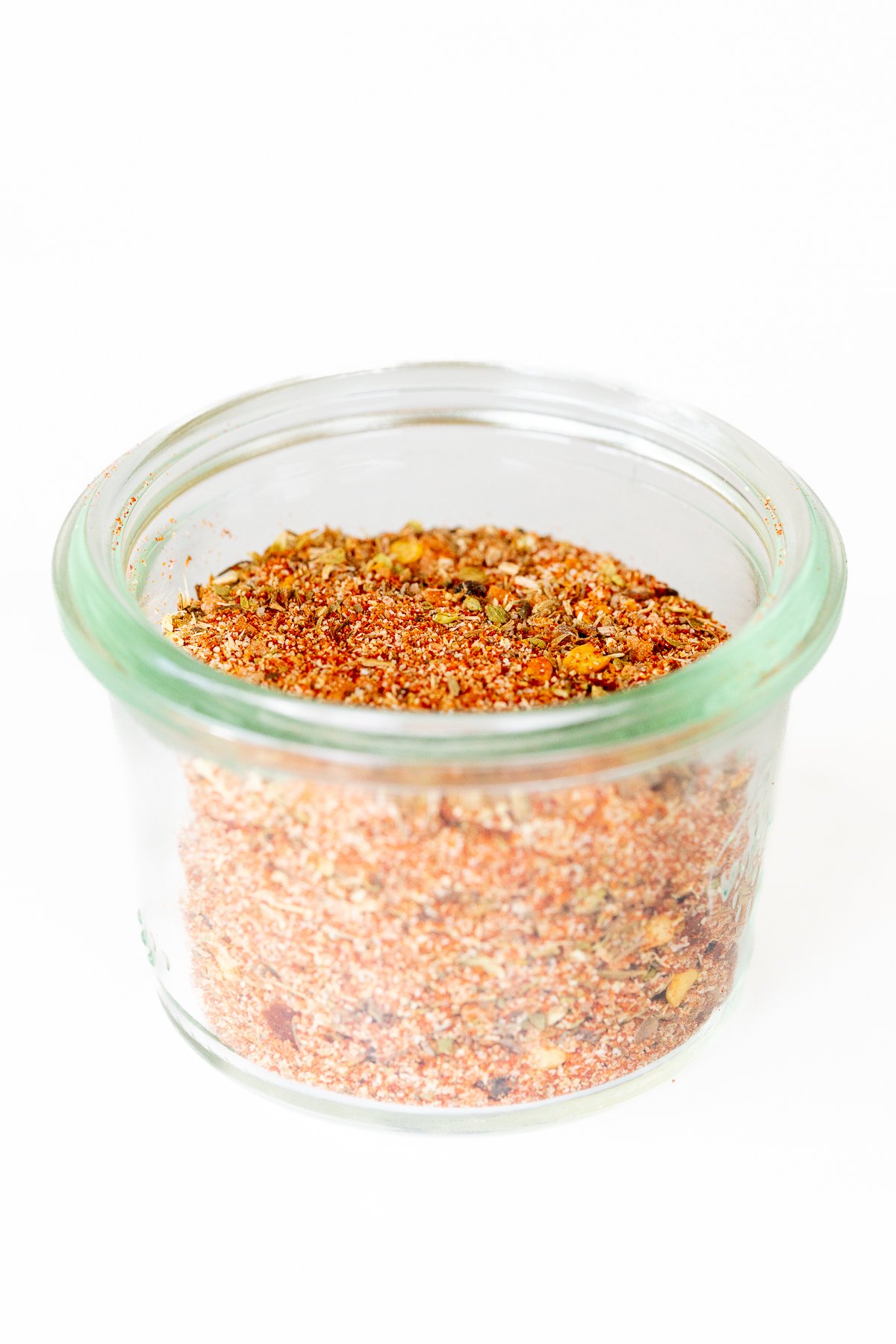 A small glass jar full of cajun seasoning.