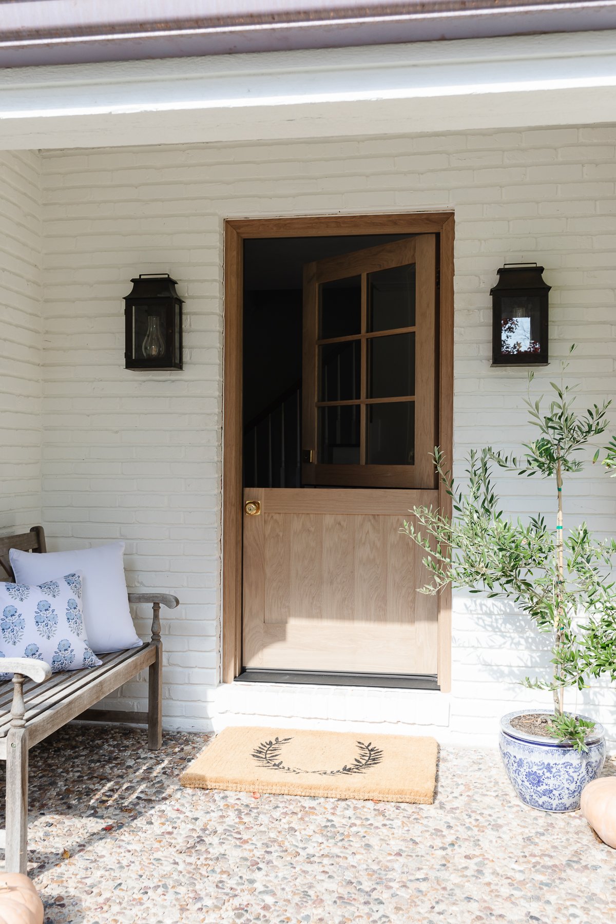 A fall front porch with blue and white accents and peach heirloom pumpkins.