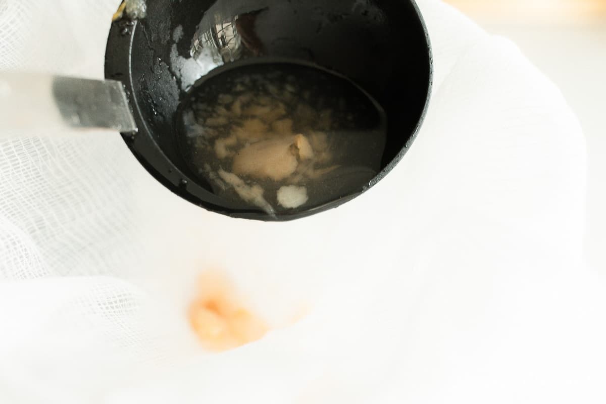 A cast iron pot filled with homemade apple cider ingredients.