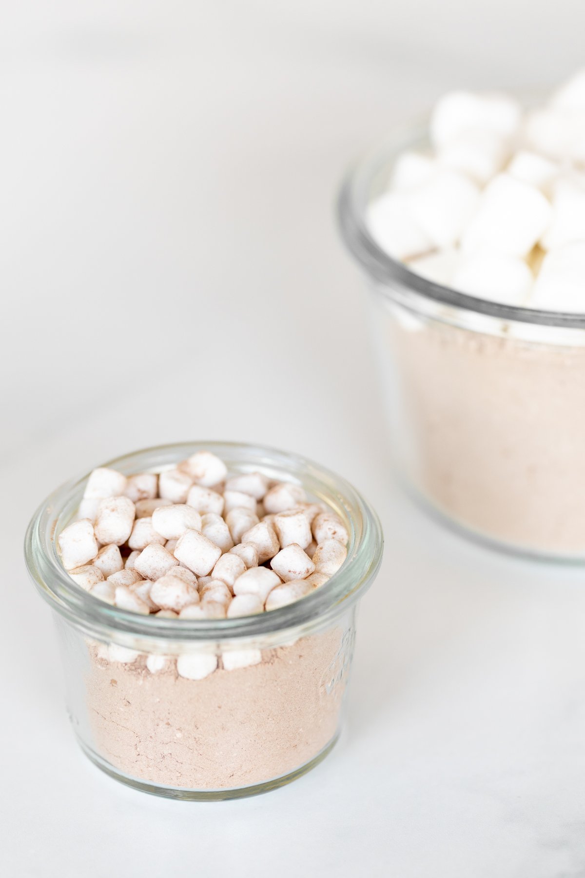 Homemade hot chocolate mix topped with marshmallows in a glass jar.