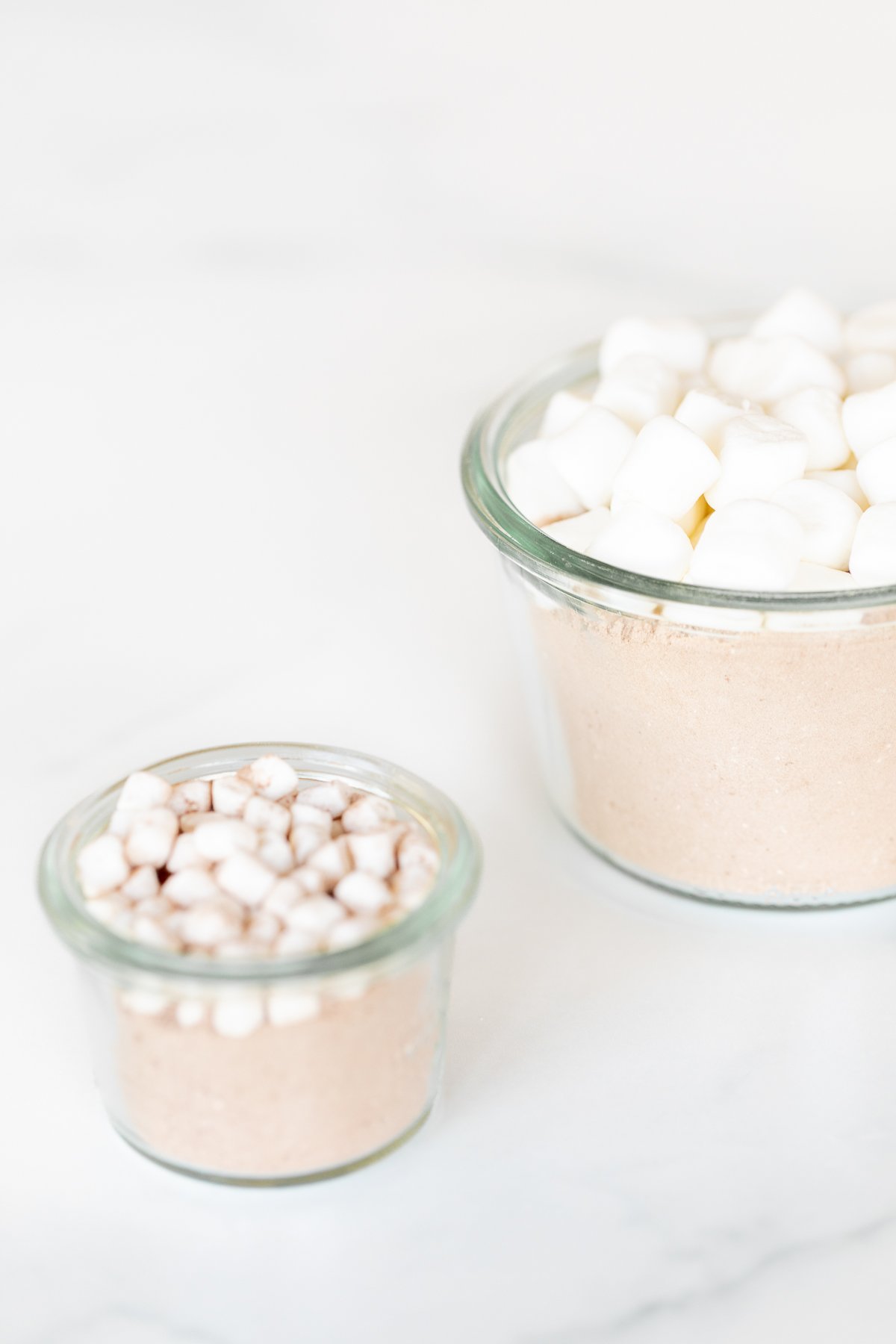 Homemade hot chocolate mix topped with marshmallows in a glass jar.