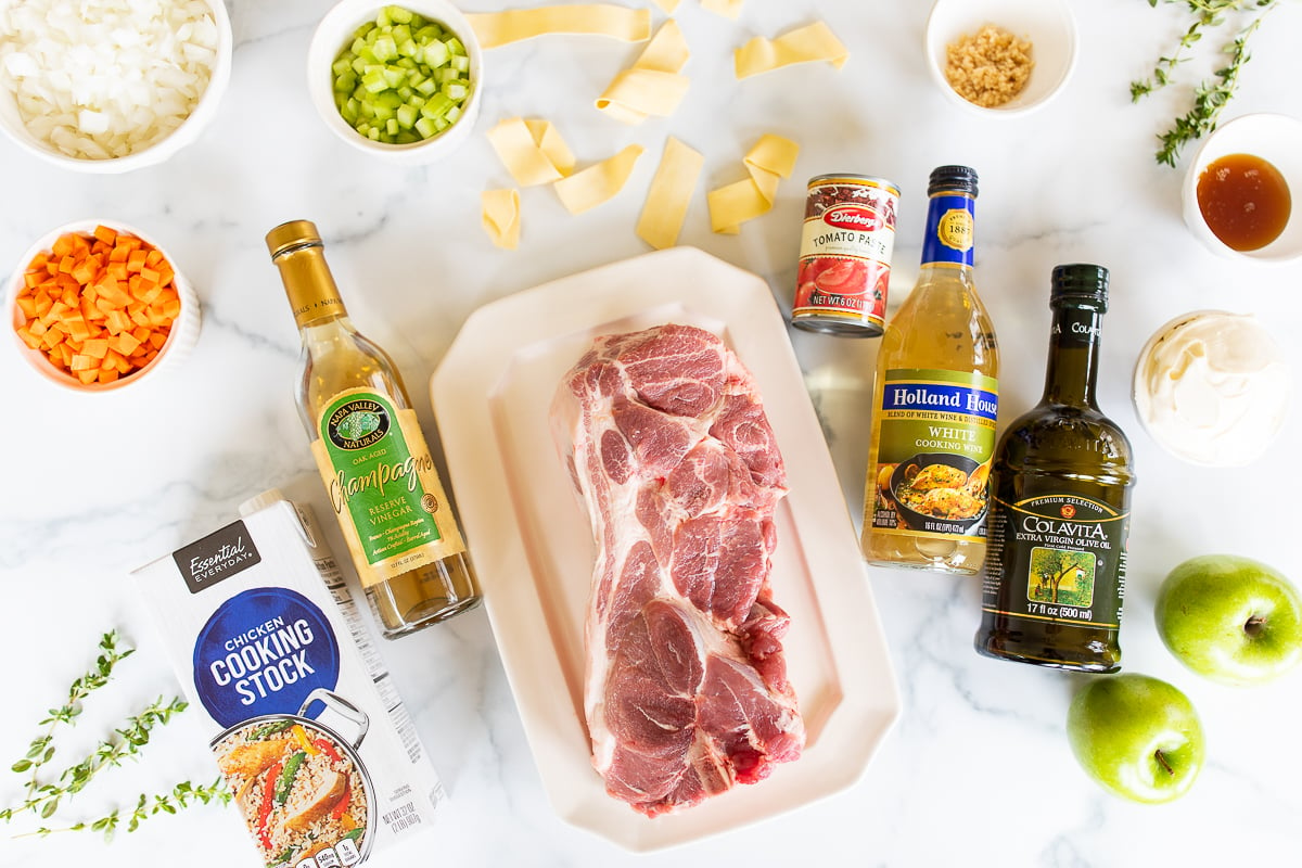 Ingredients for a pork ragu recipe on a white countertop.