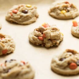 A gold sheet pan covered in fresh baked Halloween Monster Cookies.