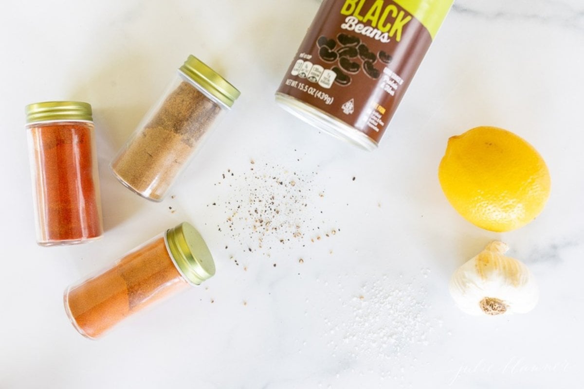 Ingredients for black bean hummus on a marble countertop.