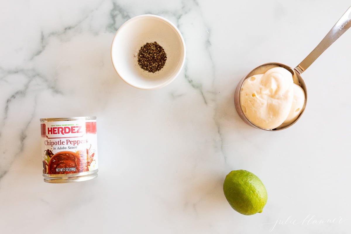 Ingredients for chipotle aioli laid out on a marble countertop.