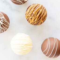 A marble surface with a variety of hot chocolate bombs.