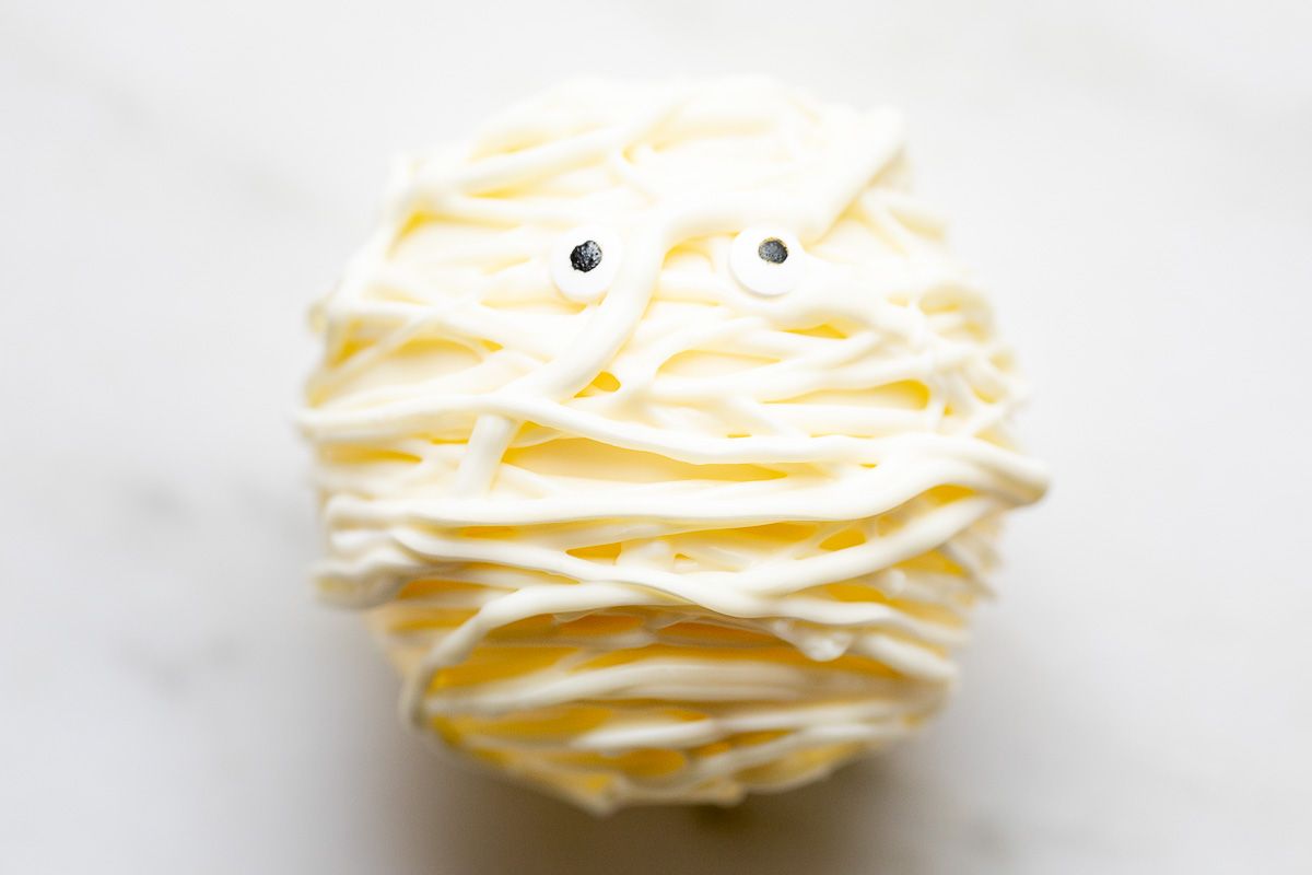 A white chocolate Halloween hot chocolate bomb, decorated as a mummy.